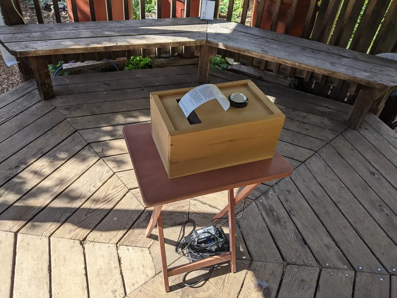 A closeup of the poetron in the gazebo with a printed poem hanging out of it